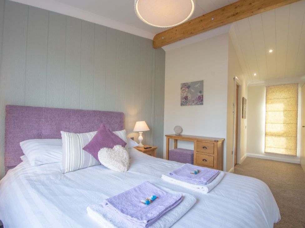 A bedroom with a double bed and side table at 2 Bedroom Sleeps 4 Lodge Smart Tv Hot tub Dogs Ok near Lochwinnoch