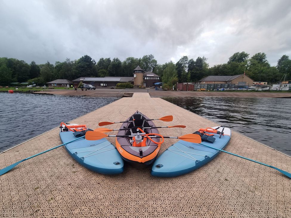 Three watercraft on a dock at 2 Bedroom Sleeps 4 Lodge Smart Tv Hot tub Dogs Ok near Lochwinnoch