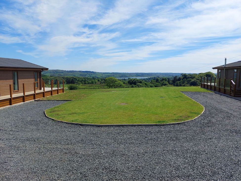 An outdoor area with two cabins and a lawn at 2 Bedroom Sleeps 4 Lodge Smart Tv Hot tub Dogs Ok near Lochwinnoch