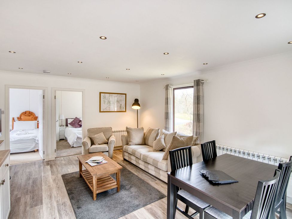 A living room with a sofa and dining table at 2 bedroom lodge with free WiFi and mountain view near Crianlarich