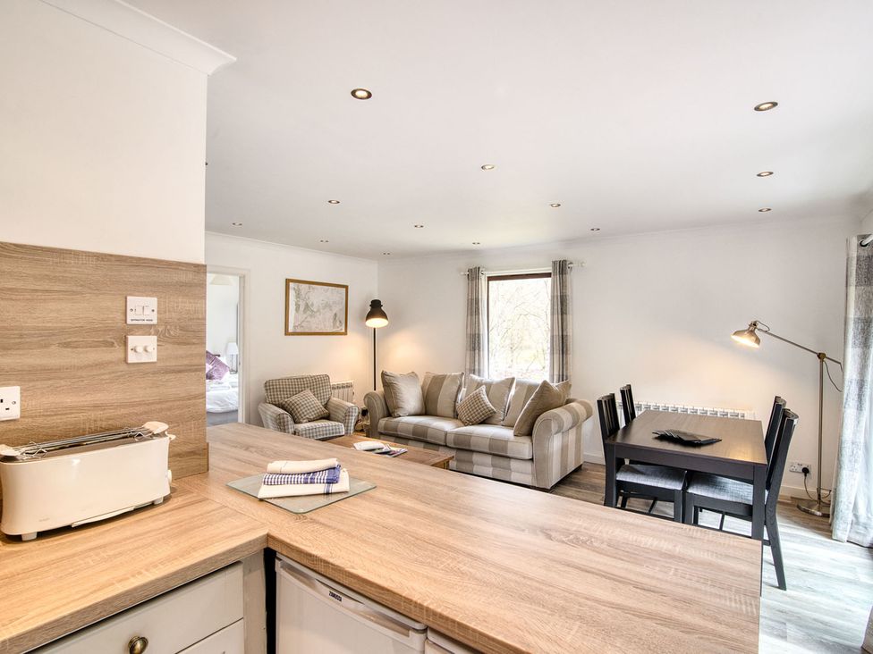 A living room with a sofa and dining table at 2 bedroom lodge with free WiFi and mountain view near Crianlarich