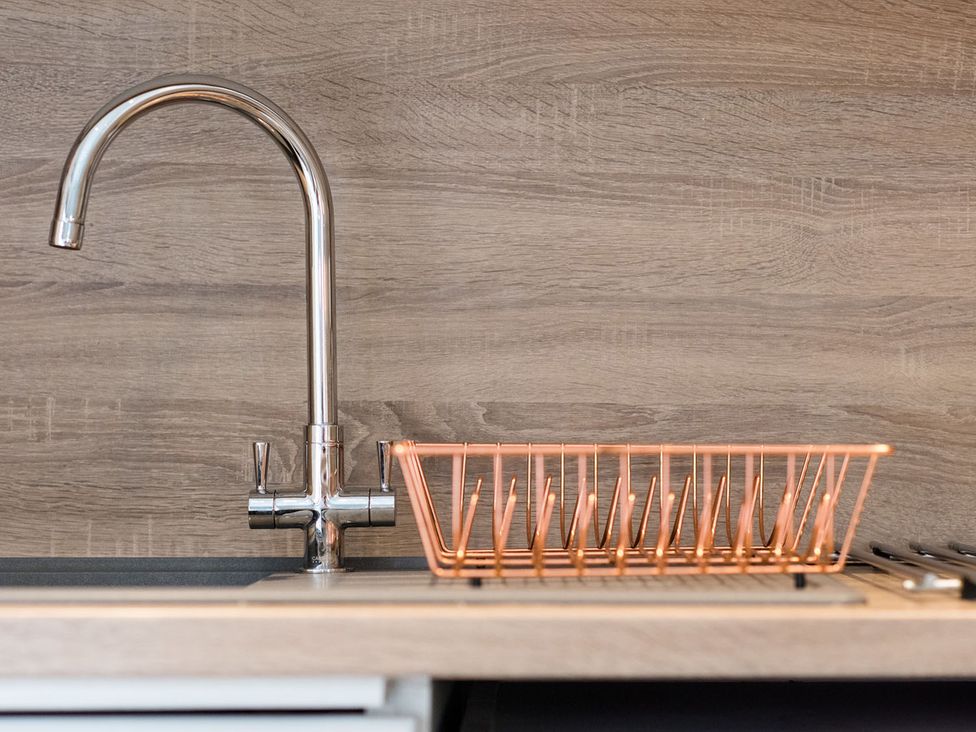 A sink with a faucet and a copper drain rack at 2 bedroom lodge with free WiFi and mountain view near Crianlarich