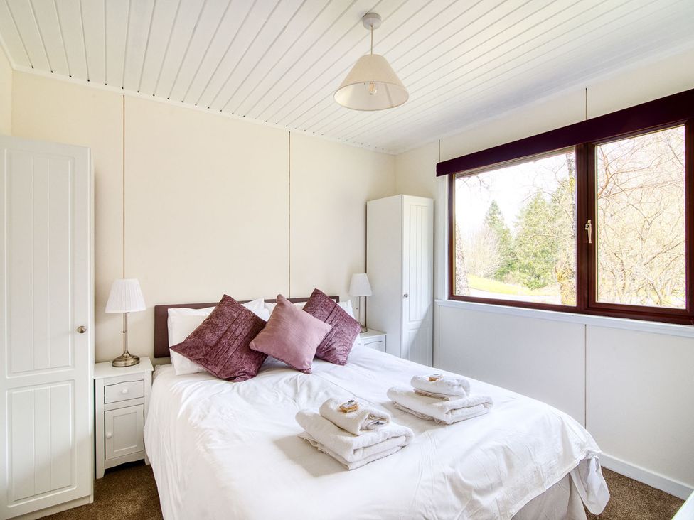A bedroom with a bed and wardrobe at 2 bedroom lodge with free WiFi and mountain view near Crianlarich