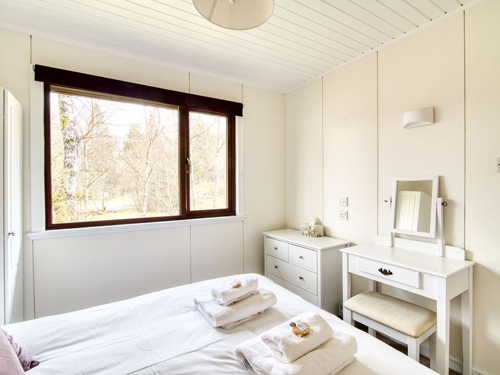 A bedroom with a bed and a window at a 2 bedroom lodge with free WiFi and mountain view near Crianlarich