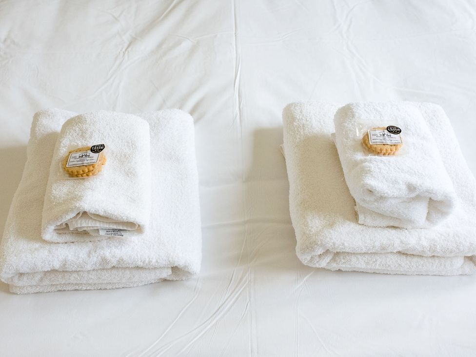 Two stacks of towels with soap on a bed at 2 bedroom lodge with free WiFi and mountain view near Crianlarich