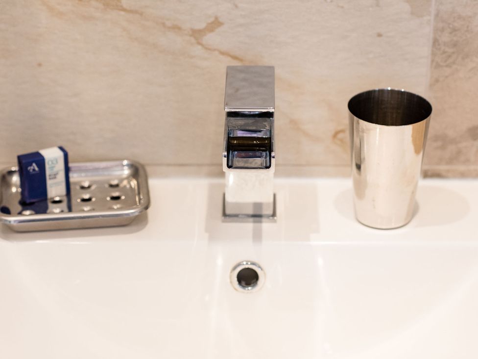 A sink with a faucet and soap tray at a bathroom in a 2 bedroom lodge with free WiFi and mountain view near Crianlarich