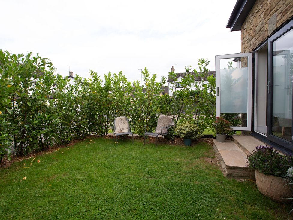 A garden with chairs and plants at Cozy Wetherby Retreat in Wetherby