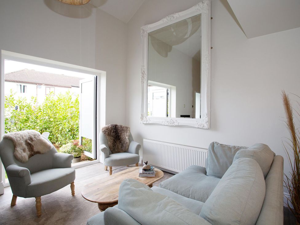 A living room with a mirror and sofas at Cozy Wetherby Retreat in Wetherby