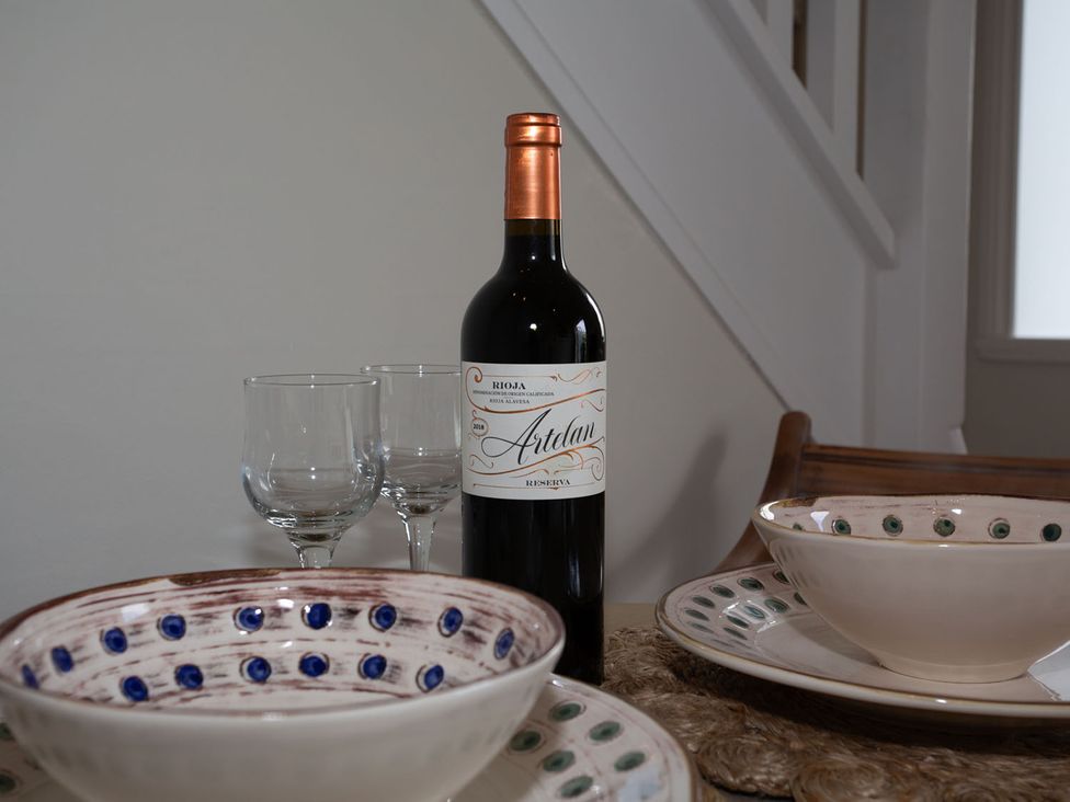 A dining room table set with wine bottle and glasses at Cozy Wetherby Retreat in Wetherby