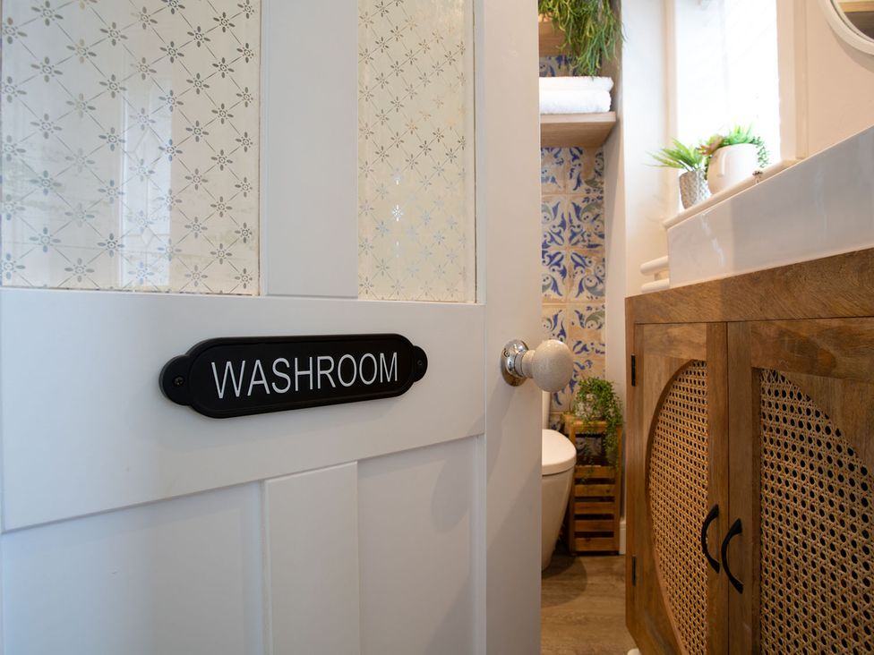 A bathroom with a door marked WASHROOM and a sink at Cozy Wetherby Retreat in Wetherby