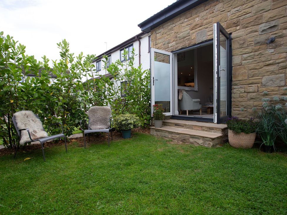 A garden with two chairs and plants at Cozy Wetherby Retreat in Wetherby