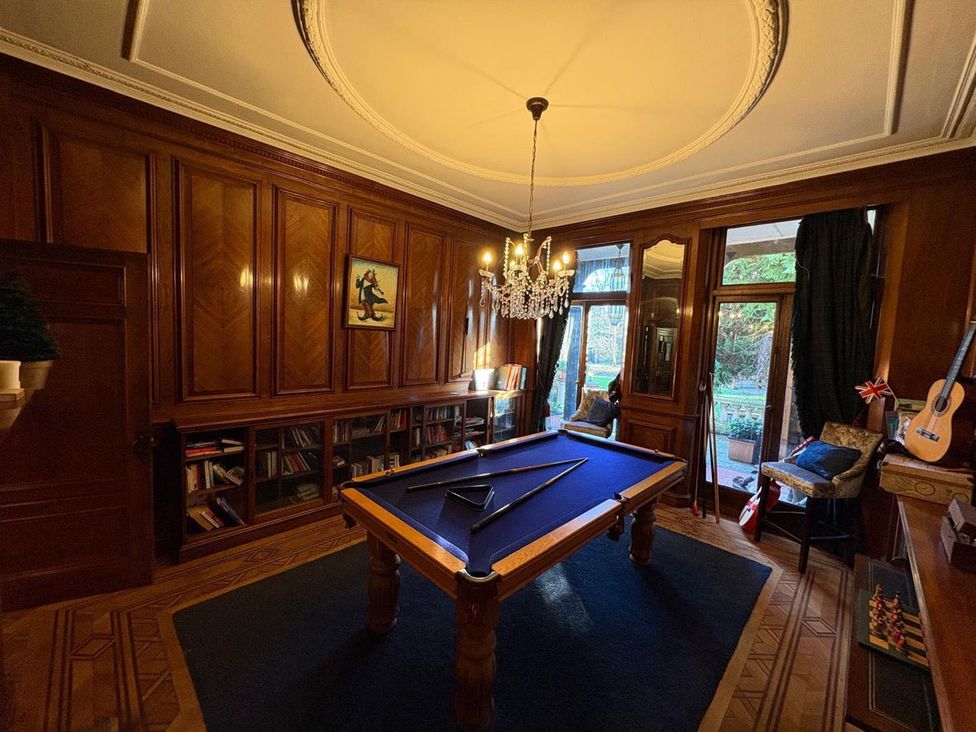 A game room with a pool table and bookshelves at the property