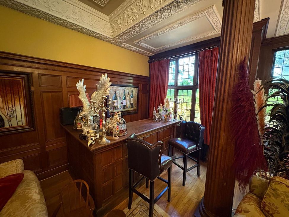 A home bar area with decorative items and bar stools at The Old Barn in Manchester