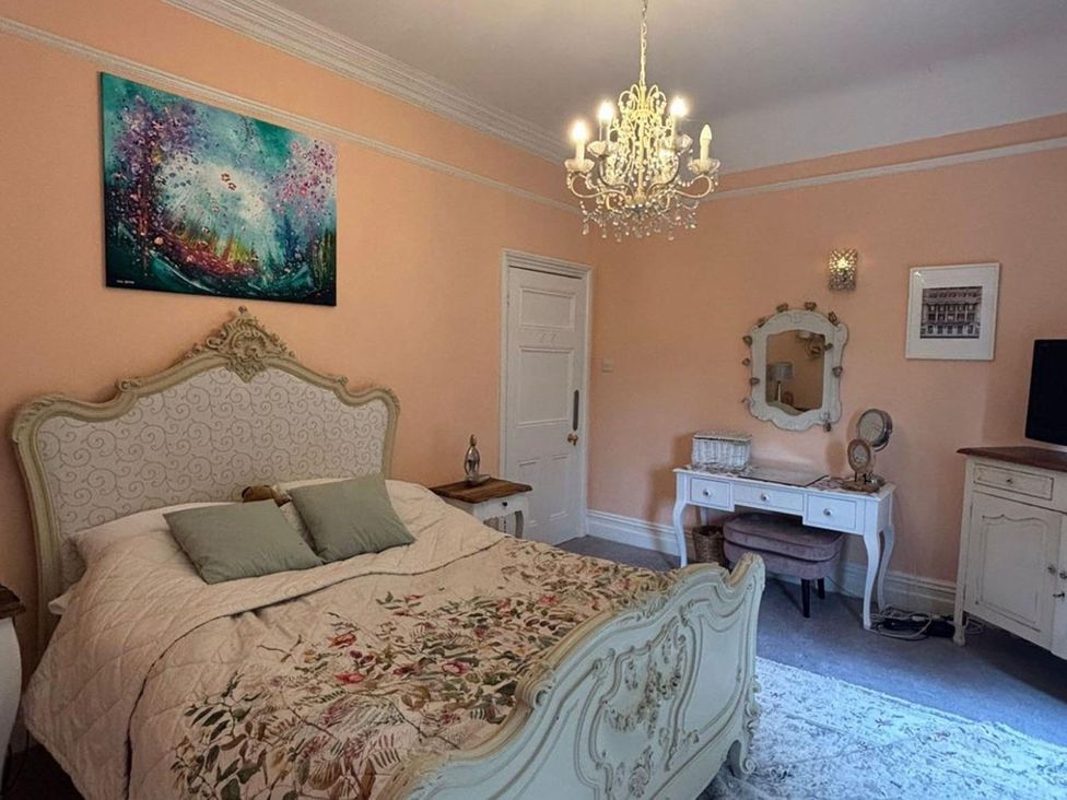 A bedroom with a bed and chandelier at the property in location 