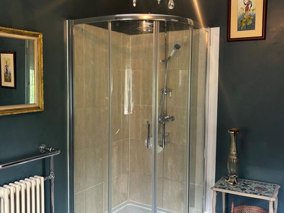 A bathroom with a shower and mirror at the property