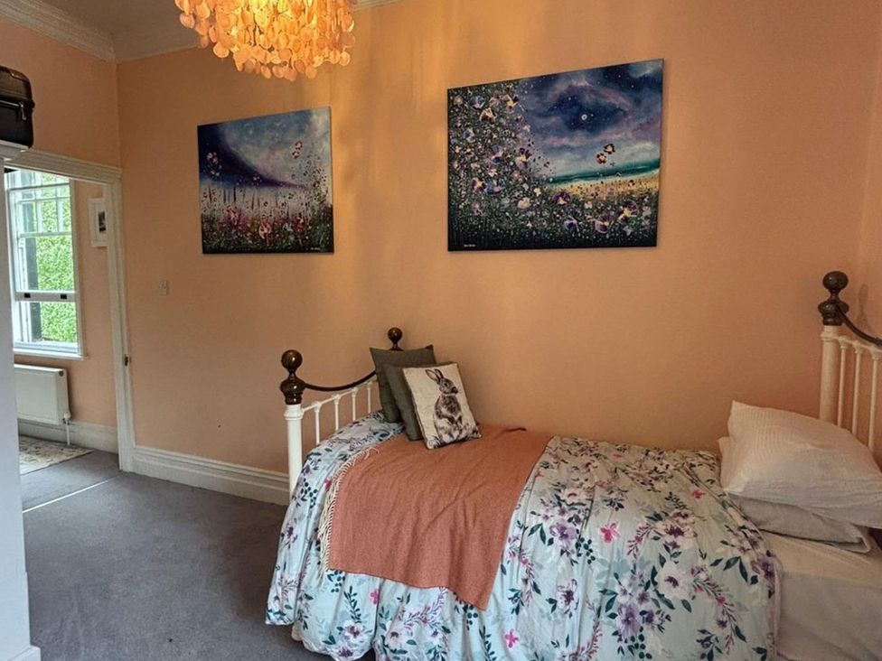 A bedroom with a bed and paintings on the wall at The Old Barn in Manchester