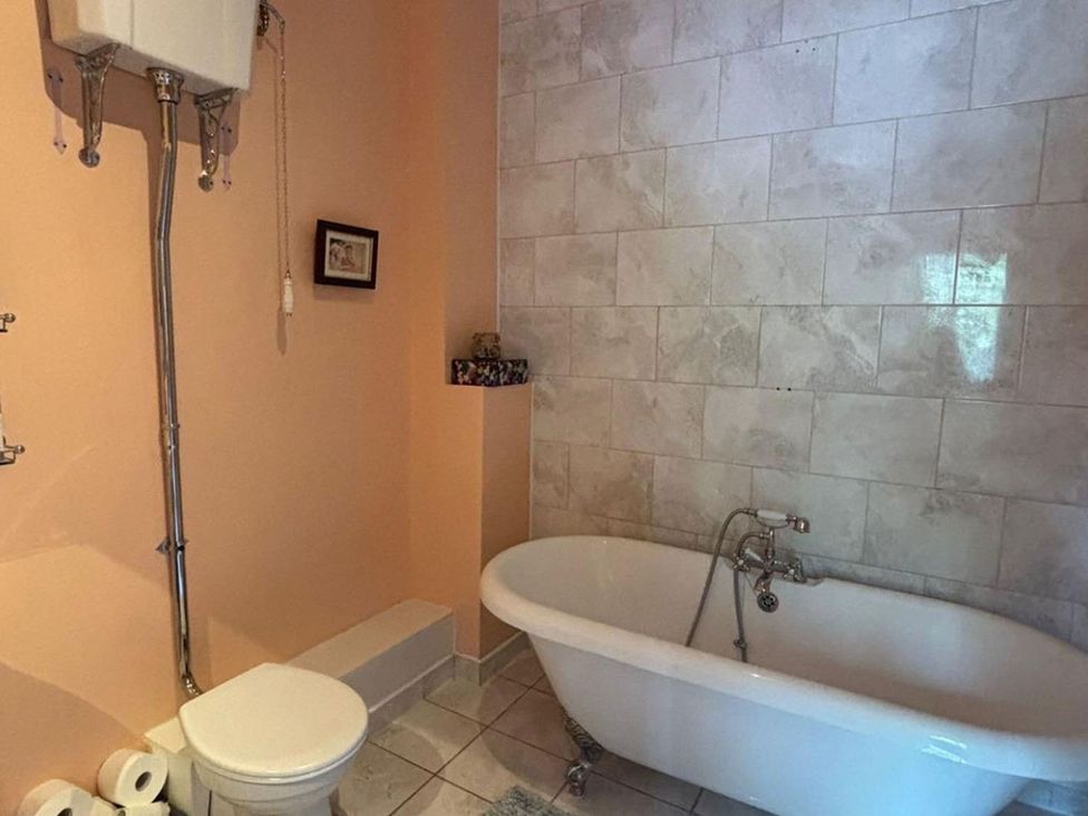 A bathroom with a bathtub and toilet located at 