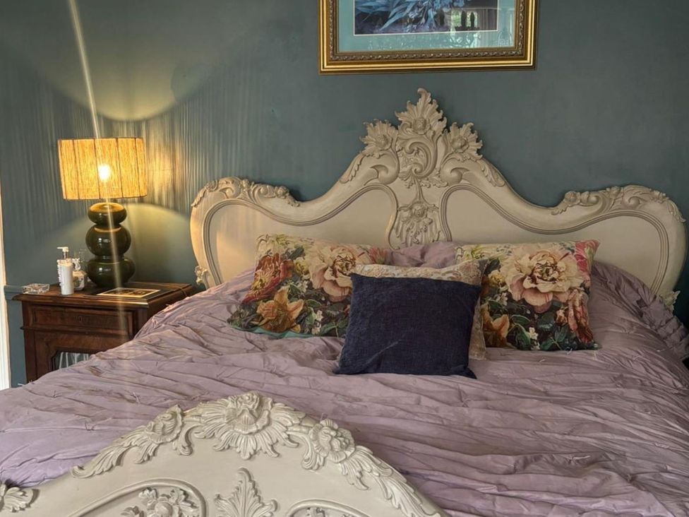 A bedroom with a bed and bedside lamp at 