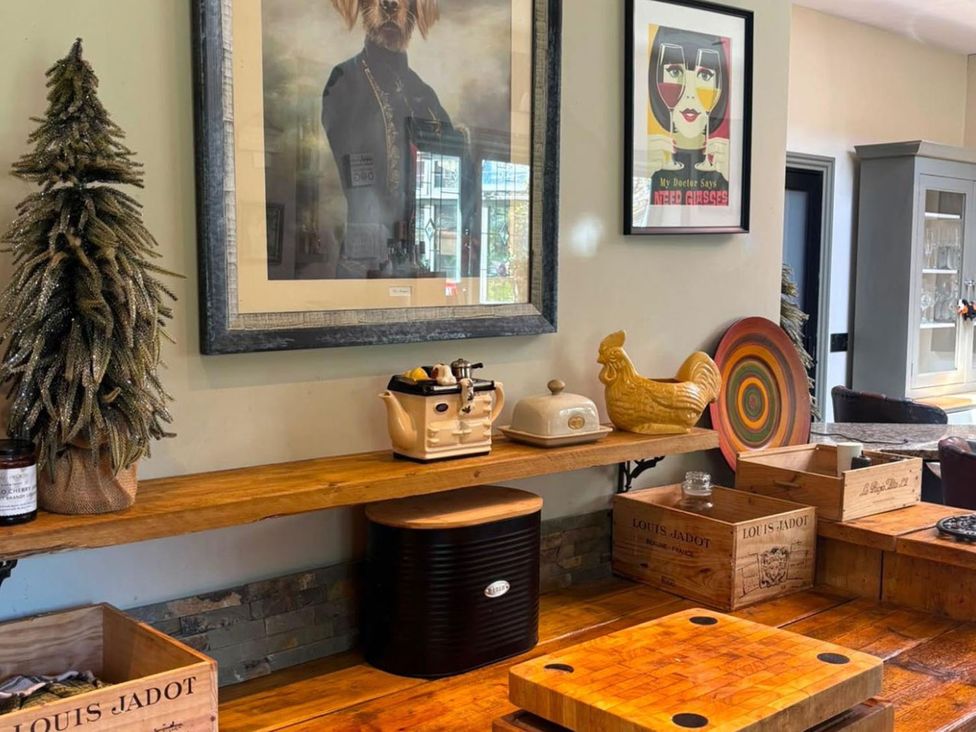 A kitchen with various decorative items and a wooden shelf at The Old Barn in Manchester