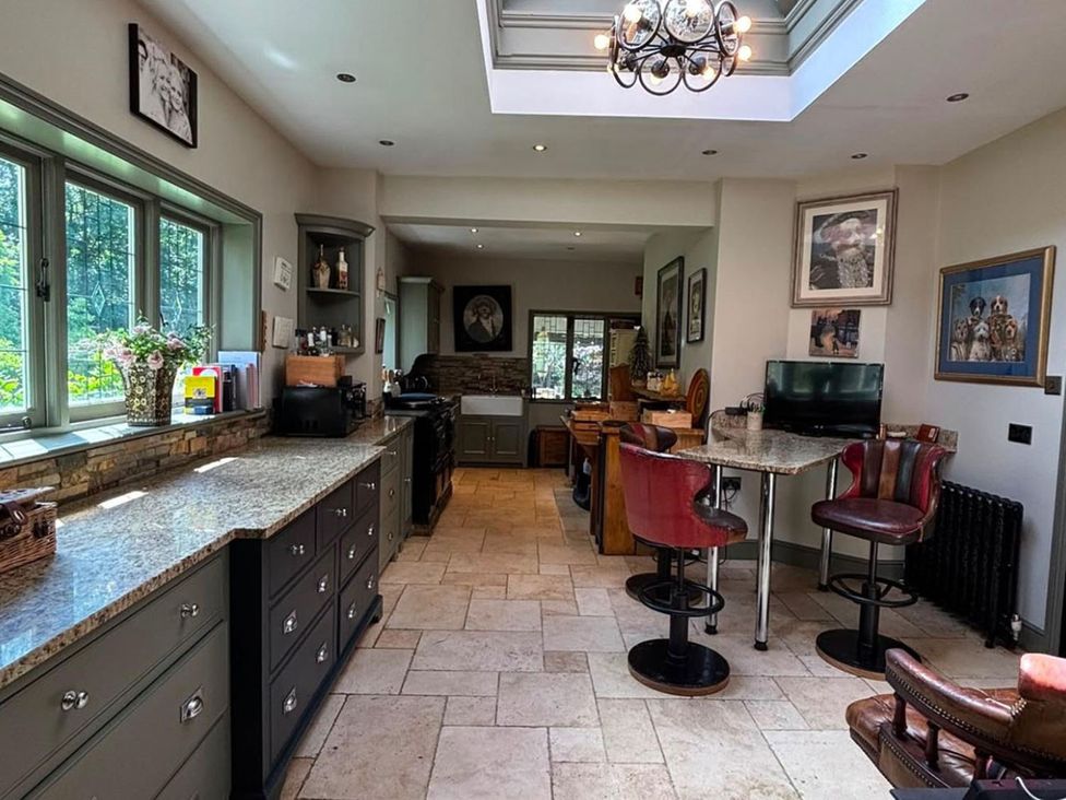 A kitchen with countertop, bar stools, and appliances at 