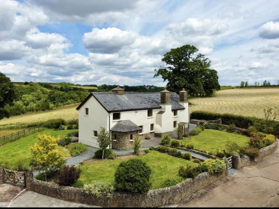An exterior view of a house with garden and driveway at the property located in outdoor settings