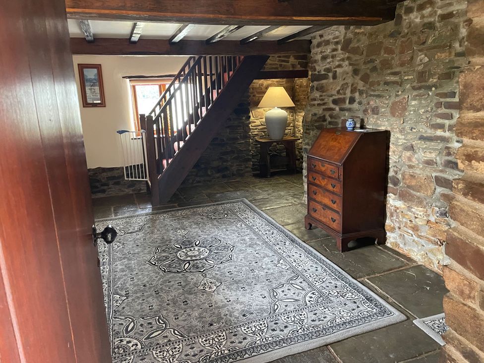 An entrance hall with a rug and staircase at the property located in 