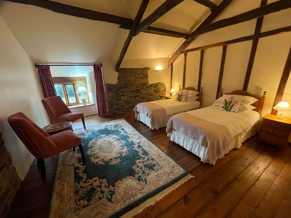 A bedroom with two beds and a chair at The Old Barn in Manchester