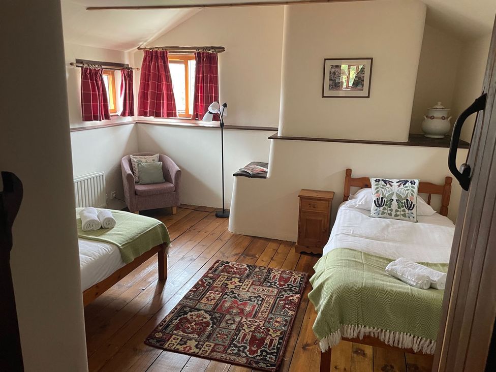 A bedroom with two beds and a chair at The Old Barn in Manchester