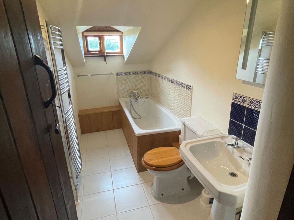 A bathroom with a bathtub, sink, and toilet at The Old Barn in Manchester
