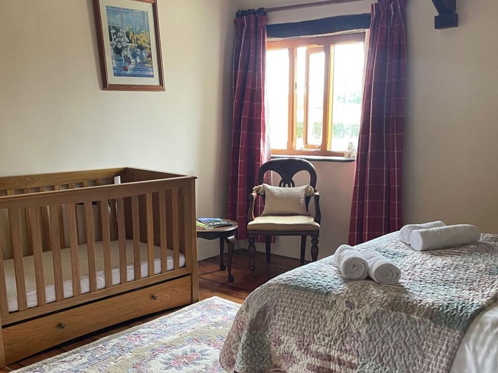 A bedroom with a crib and bedding at the property in unspecified location