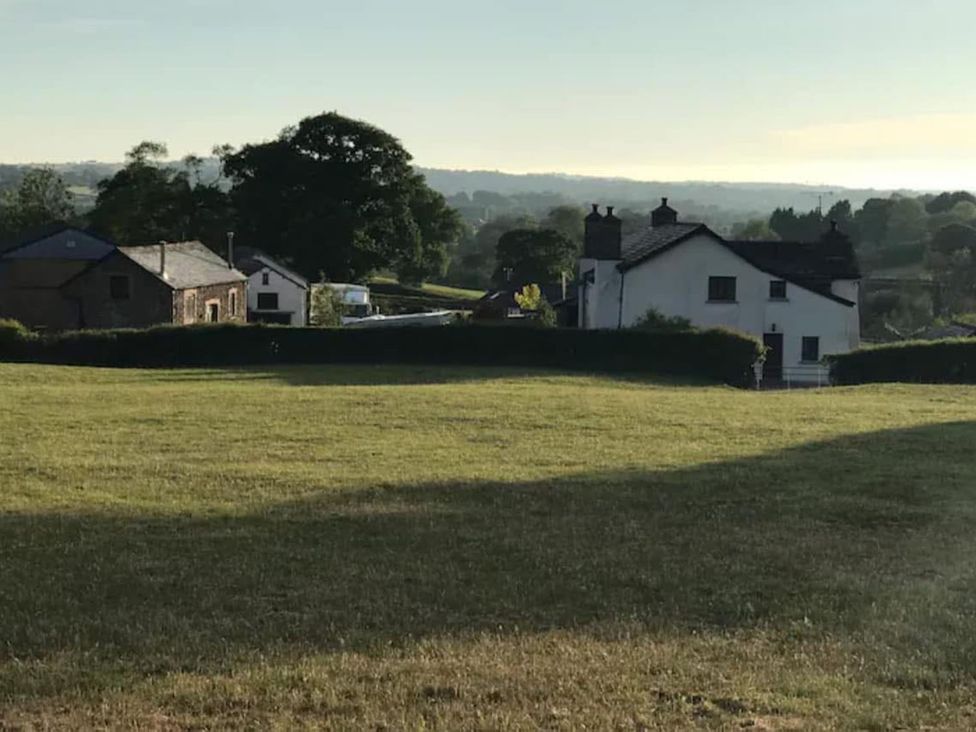 A house and field with tree in the background at a property location