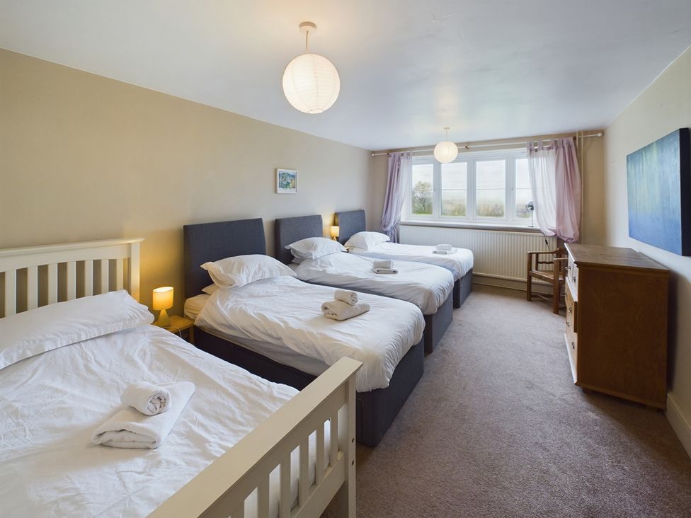 A bedroom with four beds and a window at Country House 14Guests Parking HotTub AmazingViews Kilgwrrwg near Chepstow