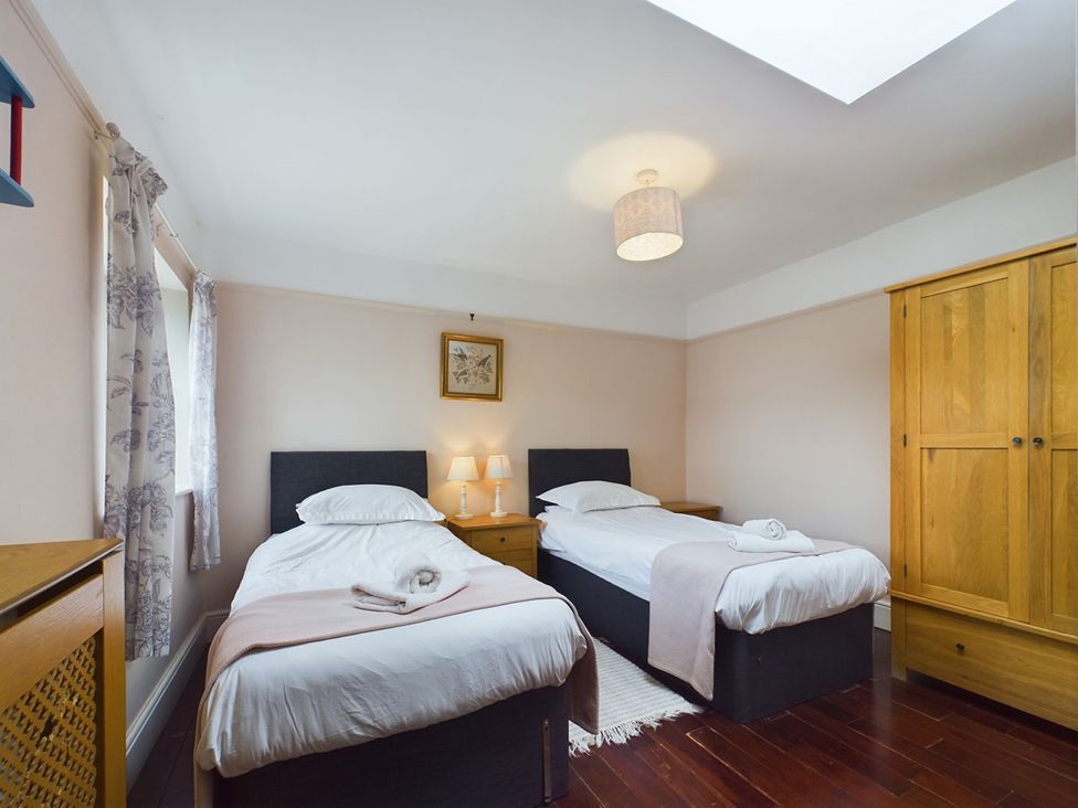 A bedroom with two beds and a wardrobe at Country House 14Guests Parking HotTub AmazingViews in Kilgwrrwg near Chepstow