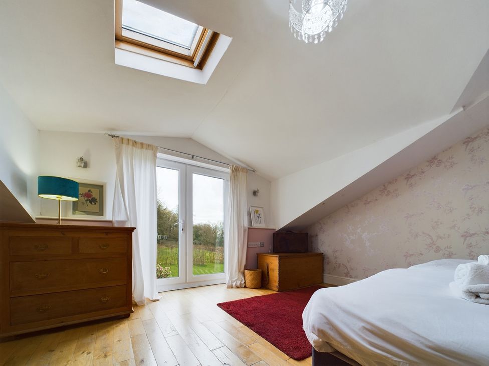 A bedroom with a bed, dresser, and skylight at Country House 14Guests Parking HotTub AmazingViews Kilgwrrwg near Chepstow