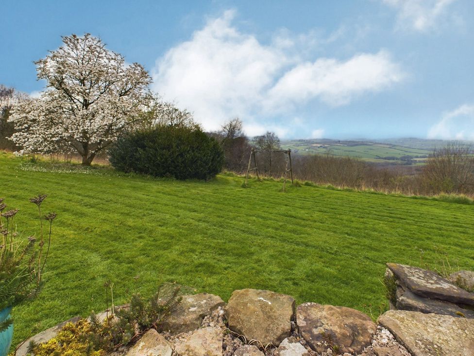 A garden with a tree, swing set, and grass at Country House 14Guests Parking HotTub AmazingViews in Kilgwrrwg near Chepstow
