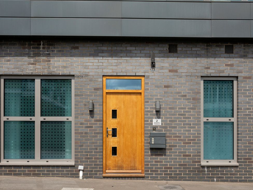 A front door with windows and a mailbox at the property Queens Lodge Sleeps 2 with Welcome Pack in Redhill