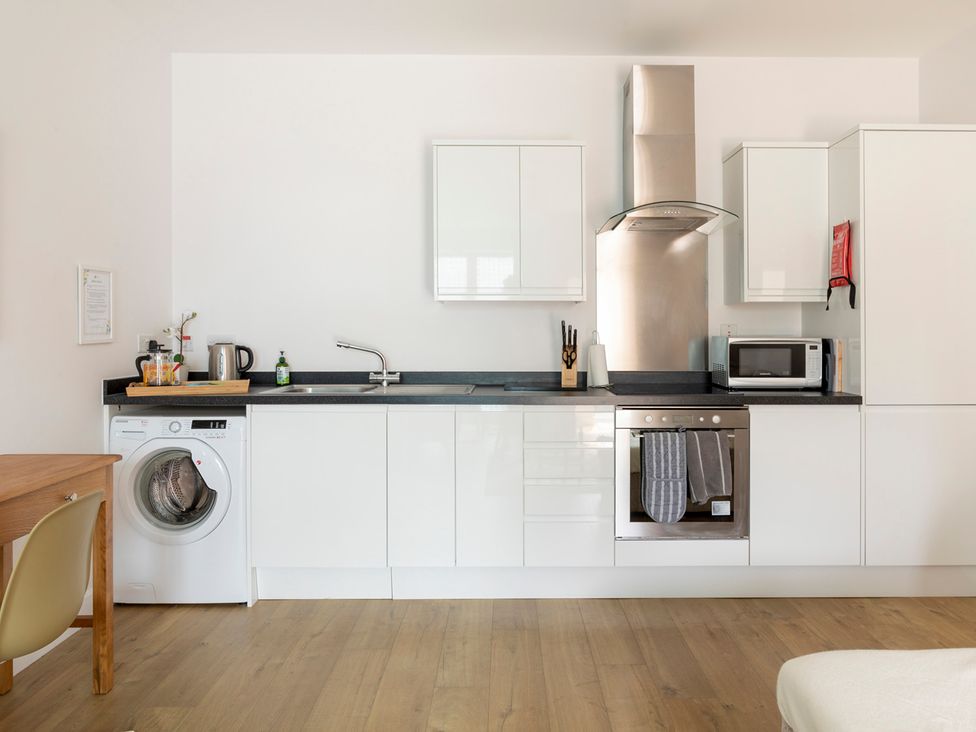 A kitchen with appliances and cabinets at Queens Lodge Sleeps 2 with Welcome Pack in Redhill