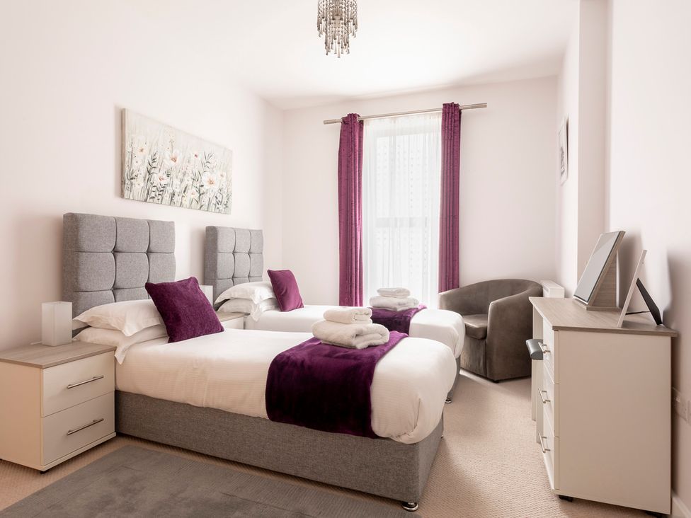 A bedroom with twin beds and a dresser at Queens Lodge Sleeps 2 with Welcome Pack in Redhill
