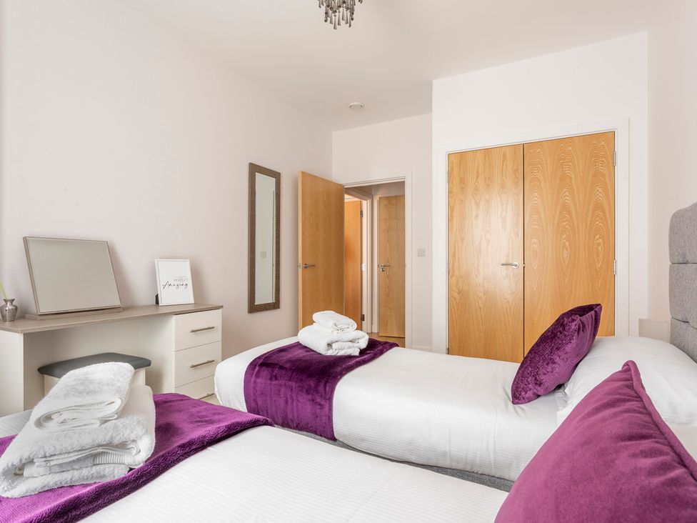 A bedroom with two beds and a mirror at Queens Lodge Sleeps 2 with Welcome Pack Redhill