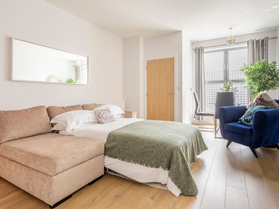 A bedroom with a sofa and bed at Queens Lodge Sleeps 2 with Welcome Pack Redhill