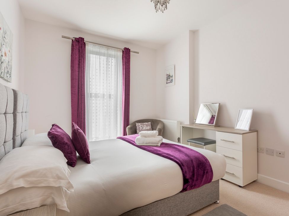A bedroom with a bed and dressing table at Queens Lodge Sleeps 2 with Welcome Pack Redhill