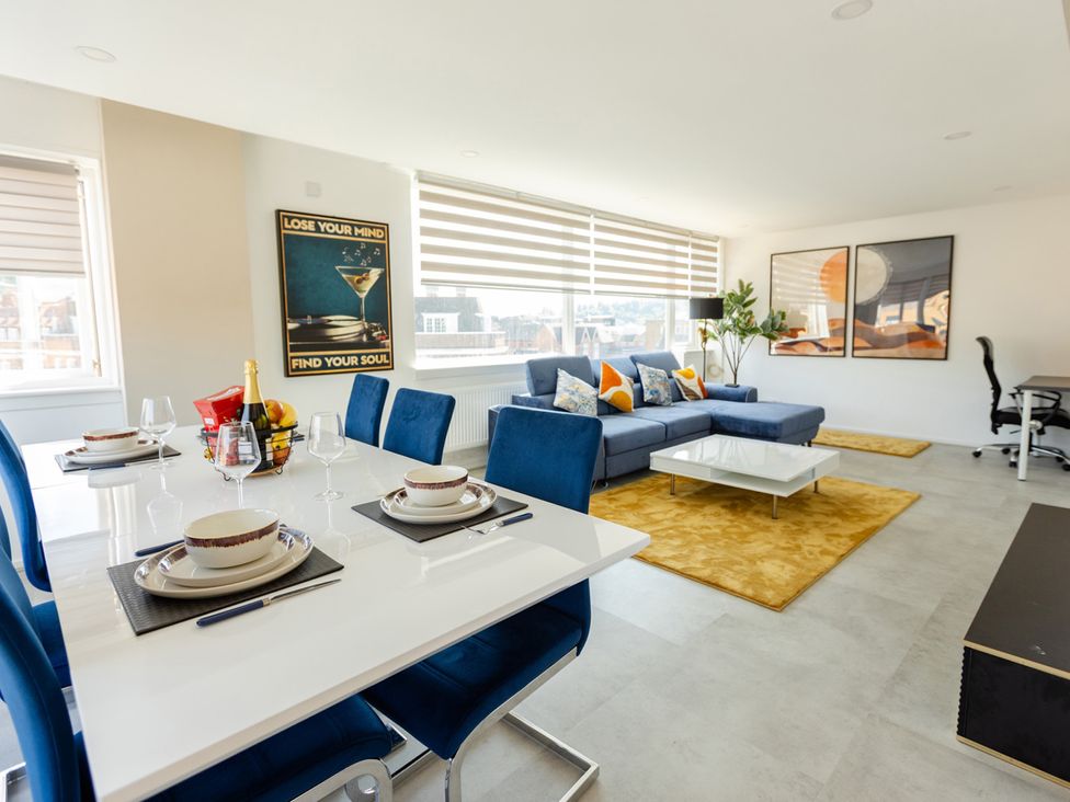 A living room with a sofa and dining area at Apartment Sleeps 6 Parking WiFi in Guildford