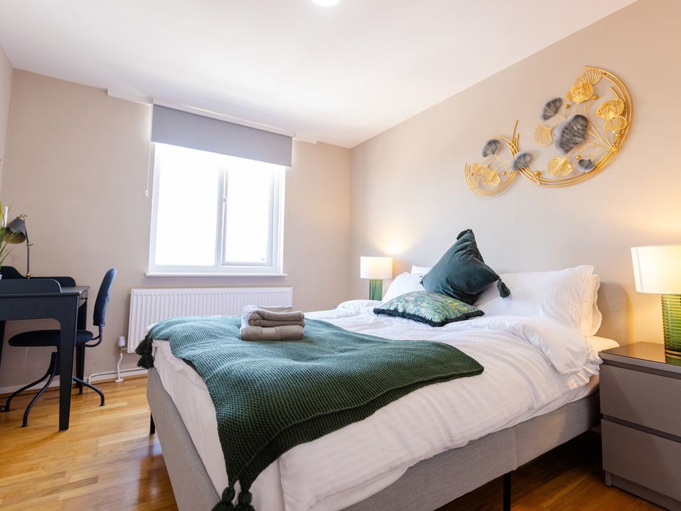 A bedroom with a bed and a desk at Apartment Sleeps 6 Parking WiFi Guildford