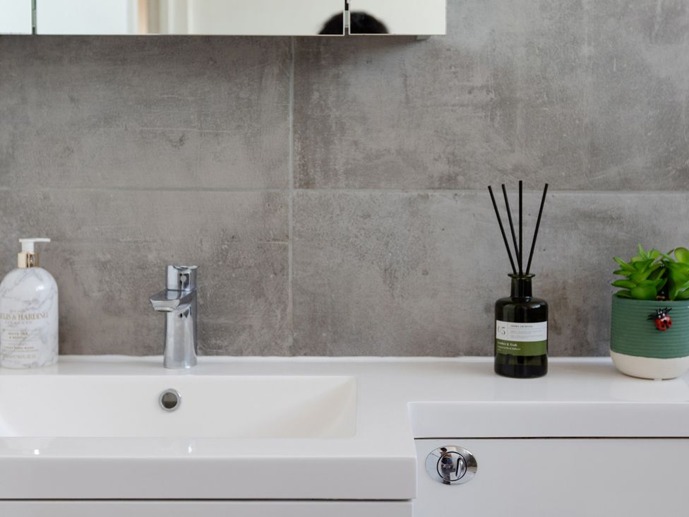 A sink with a faucet and soap dispenser in the bathroom at Apartment Sleeps 6 Parking WiFi Guildford