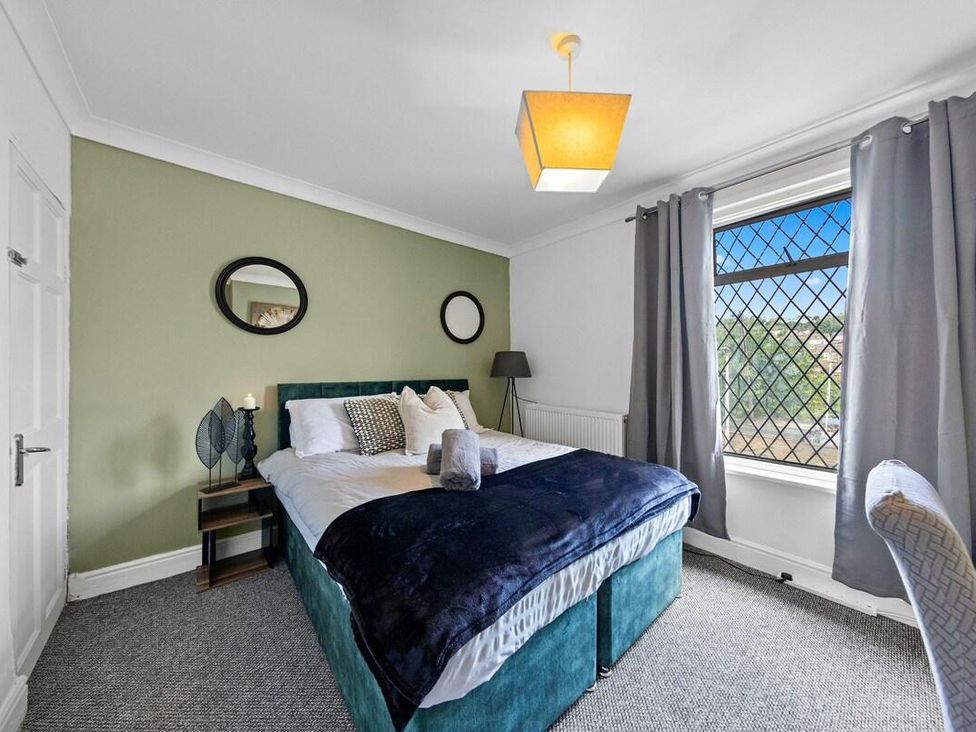 A bedroom with a bed and mirrors at Apartment Sleeps 7 with Free Parking in Chatham