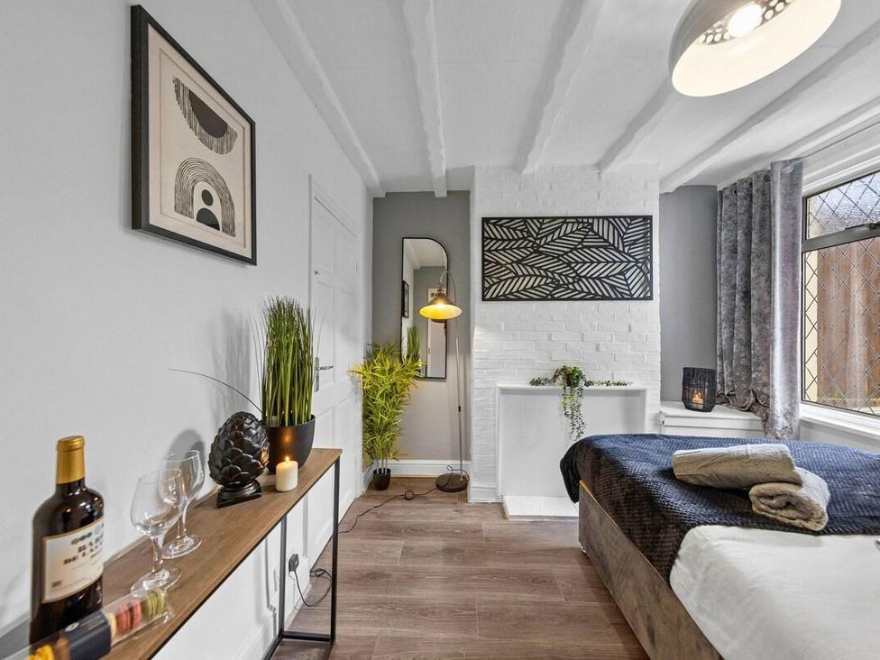 A bedroom with a bed and decorative items at Apartment Sleeps 7 with Free Parking, Chatham