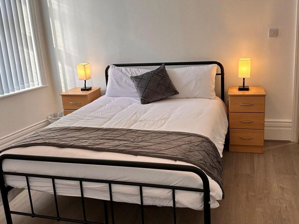 A bedroom with a bed and bedside tables at Near Beach Parking WiFi Sleeps 2 in Lytham St Annes