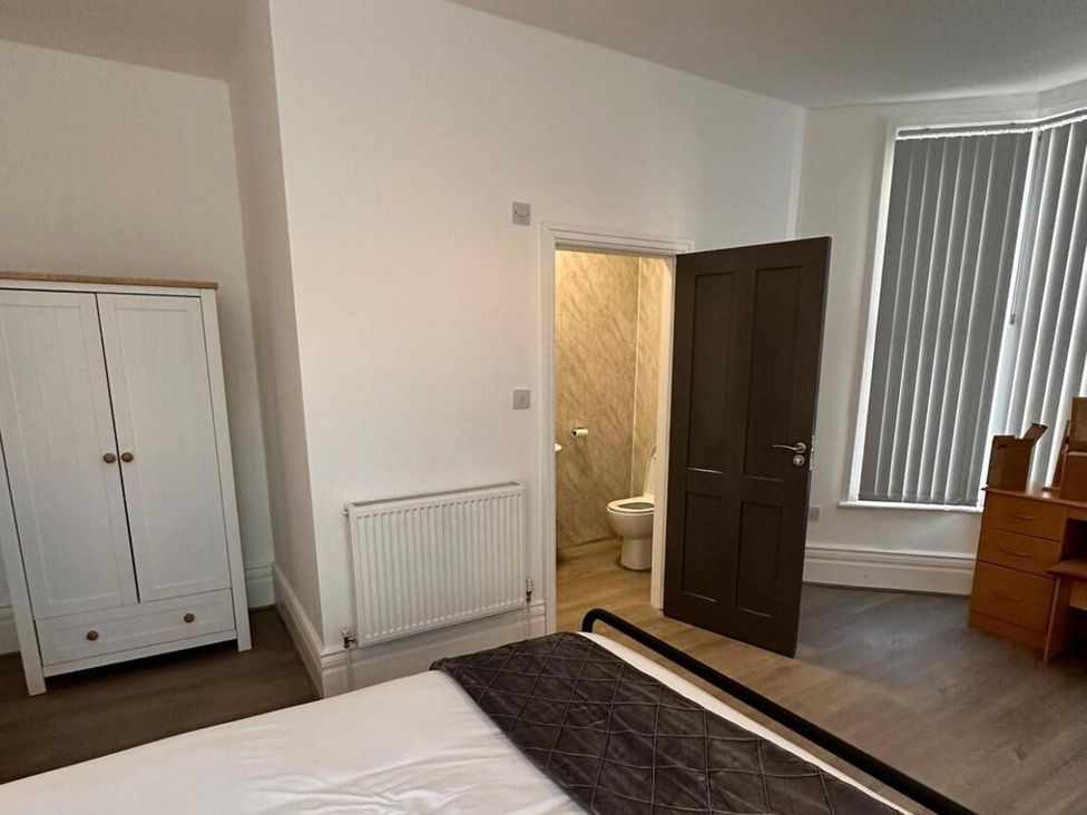 A bedroom with a bed and wardrobe at Near Beach Parking WiFi Sleeps 2 in Lytham St Annes