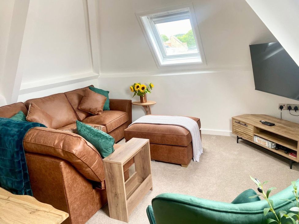 A living room with a sofa, table, and television at Central Tenby 3 Bed Apt Sleeps 6 to 8 Dog Friendly, Tenby