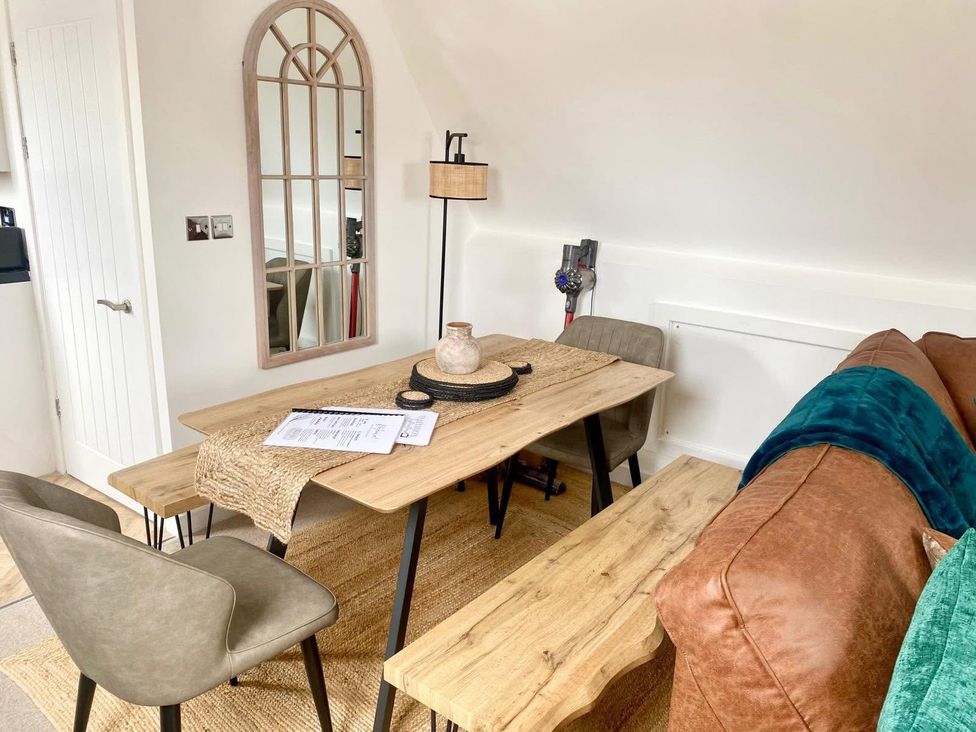 A dining area with a table and chairs at Central Tenby 3 Bed Apt Sleeps 6 to 8 Dog Friendly in Tenby